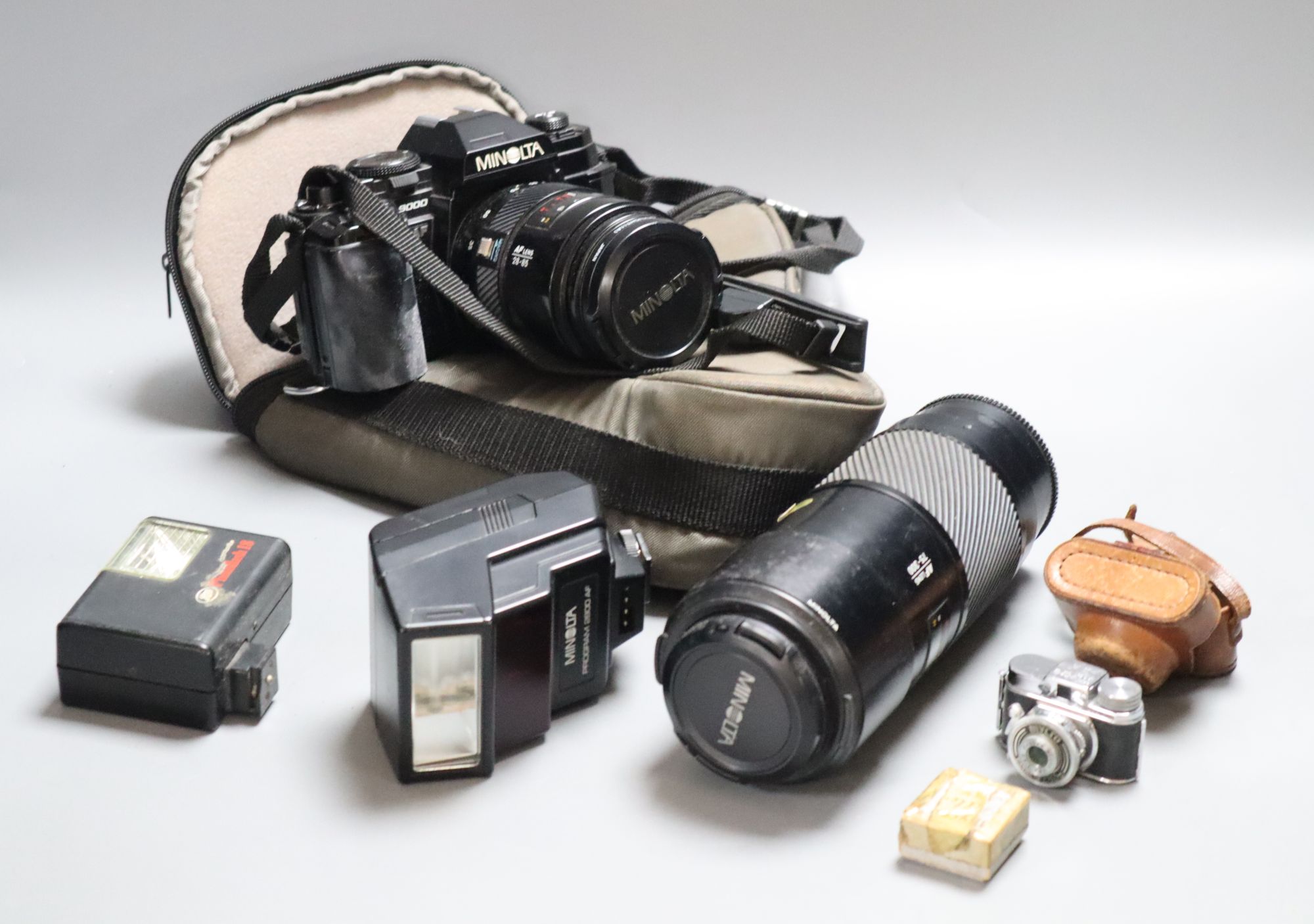 A Minolta 9000 SRL camera, a Minolta 75-300 zoom lens, with flash, together with a Sanwa Mycro miniature camera, with leather case